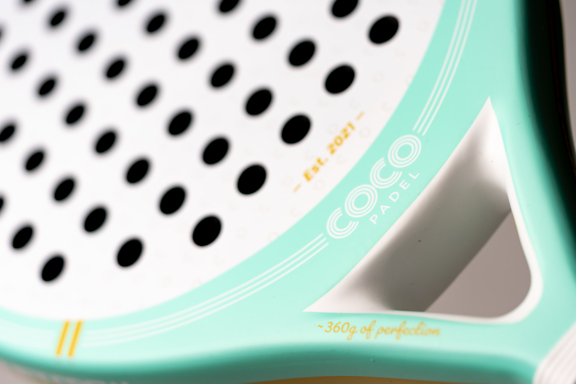 Close-up of a mint COCO racket with the COCO Padel mark